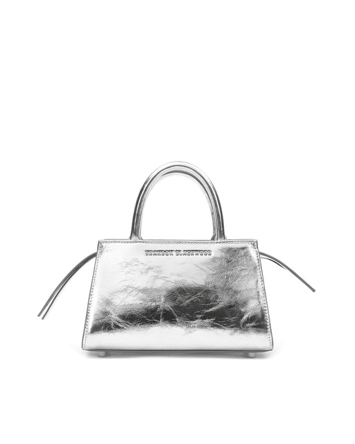Front of Arlen Bag, metallic silver leather body with leather handle, Brandon Blackwood hardware logo, exaggerated zipper detail 